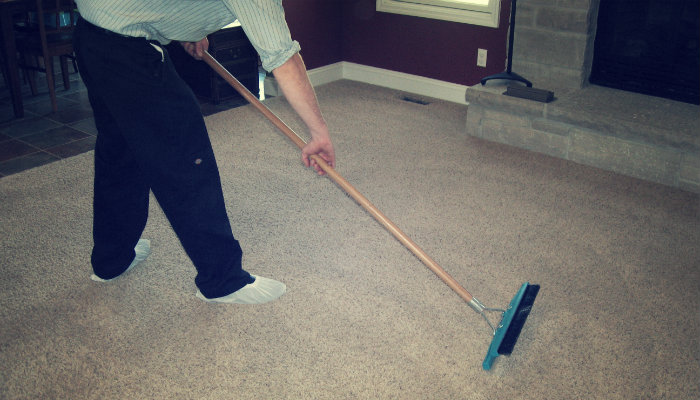 cropped image of a man using squeegee on office carpet