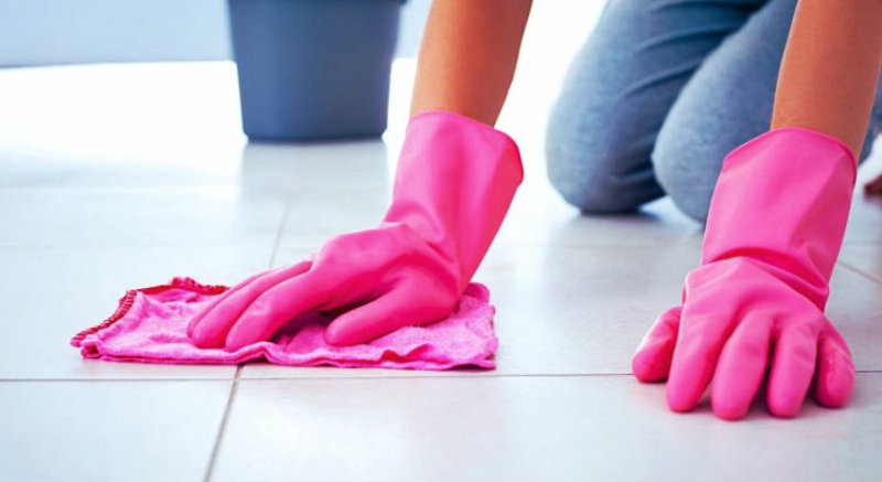 cropped image of a woman wiping tile floor
