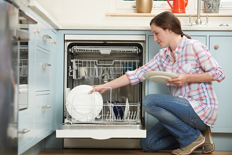 woman doing dishes in a dishwasher