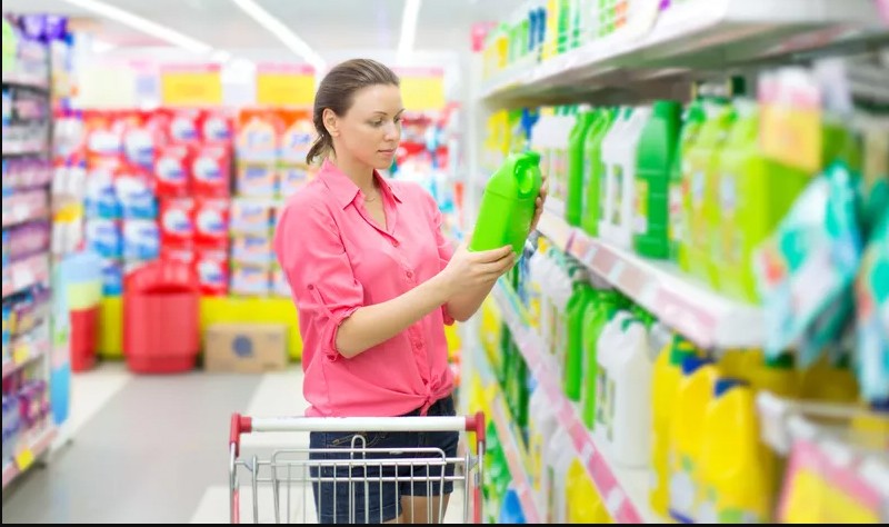 Woman wearing pink shirt holding a gallon in hand