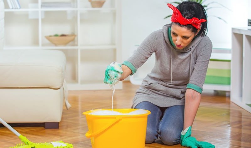 young woman preparing to mop the floor with a cloth mop