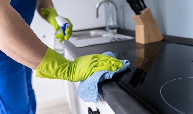 cropped picture of a professional wiping a surface with a cloth rag