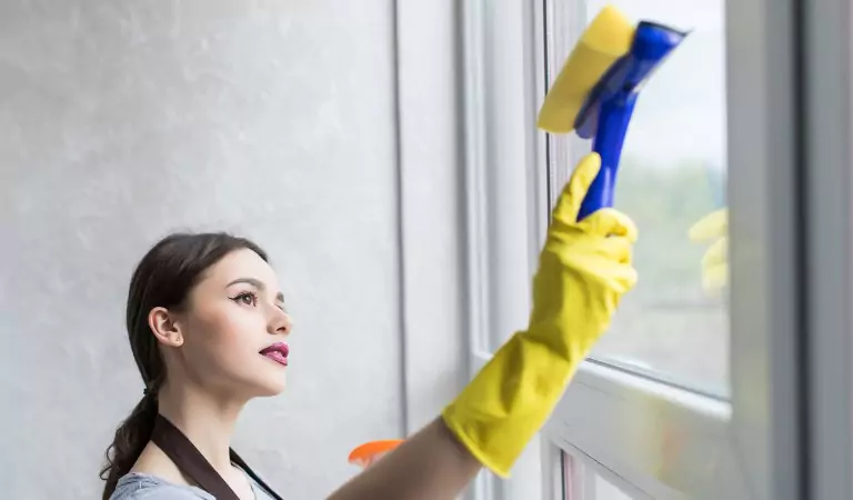 young woman wiping the window glass with a wiper