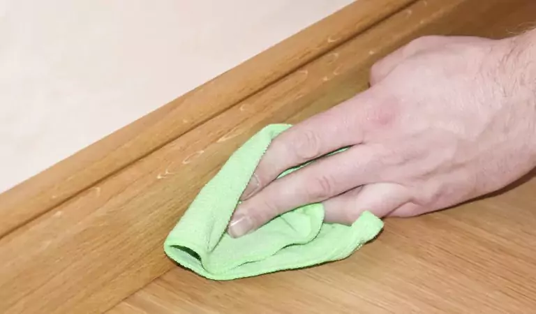 cropped picture of a person cleaning the skirting boards