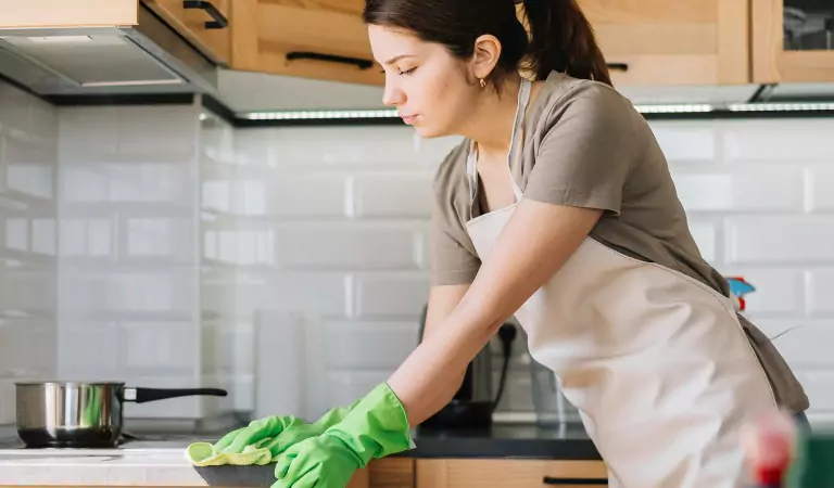 young woman wiping a kitchen surface