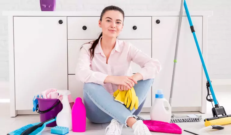 woman sitting on the floor with some cleaning supplies