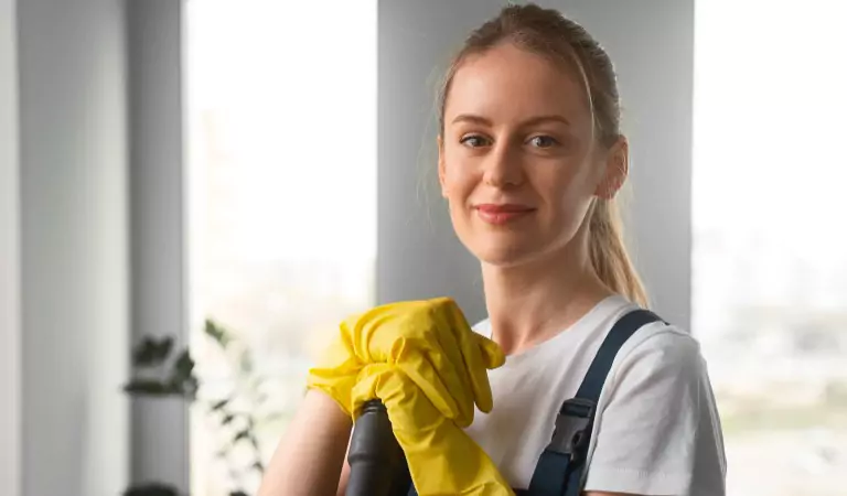 woman inside of a house wearing yellow gloves ready to clean