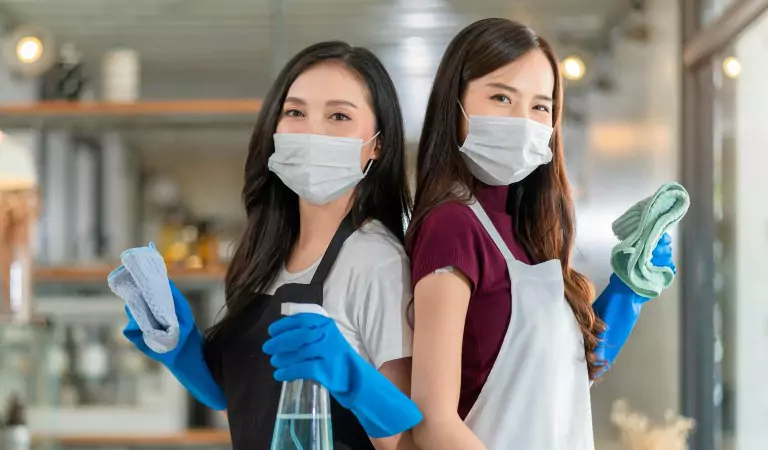 Two young women with some cleaning spray and cloth mop ready to clean