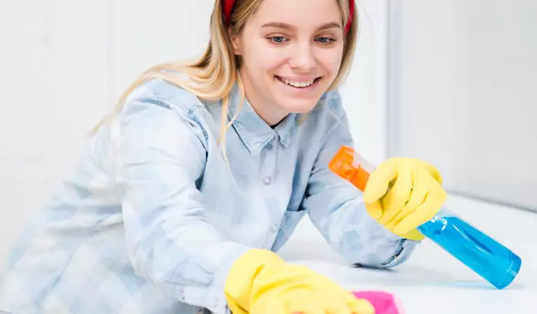 woman disinfecting a surface with a cleaner and cloth mop