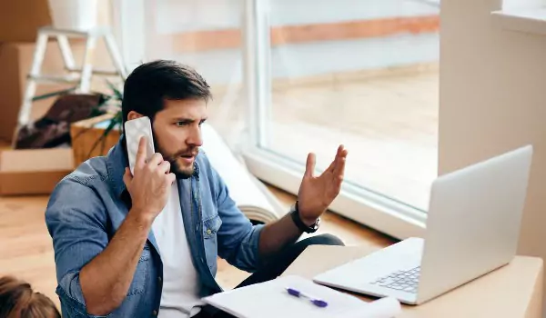 young man looking angry while talking over a phone