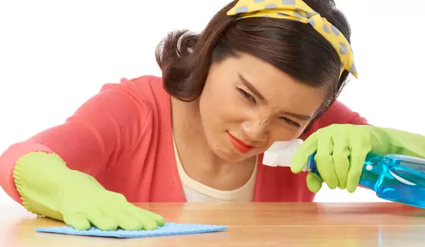 woman disinfecting a surface with a cleaner