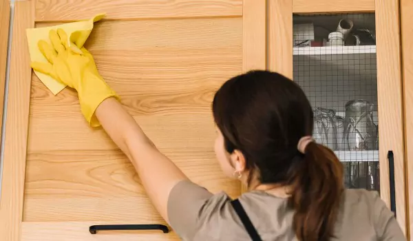 woman cleaning kitchen cabinet