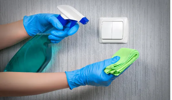 Disinfecting light switch to prevent coronavirus infection. House cleaning during a pandemic.Llight switch cleaning