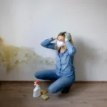 Side view of young woman standing against wall