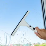 Cleaning window with special brush on the the blue sky