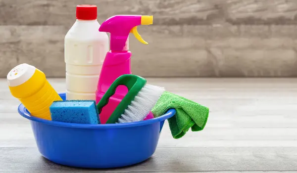 Cleaning supplies in a blue bowl wooden floor background